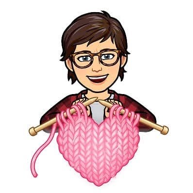 Lea-Ann holding knitting needles making a pink heart.